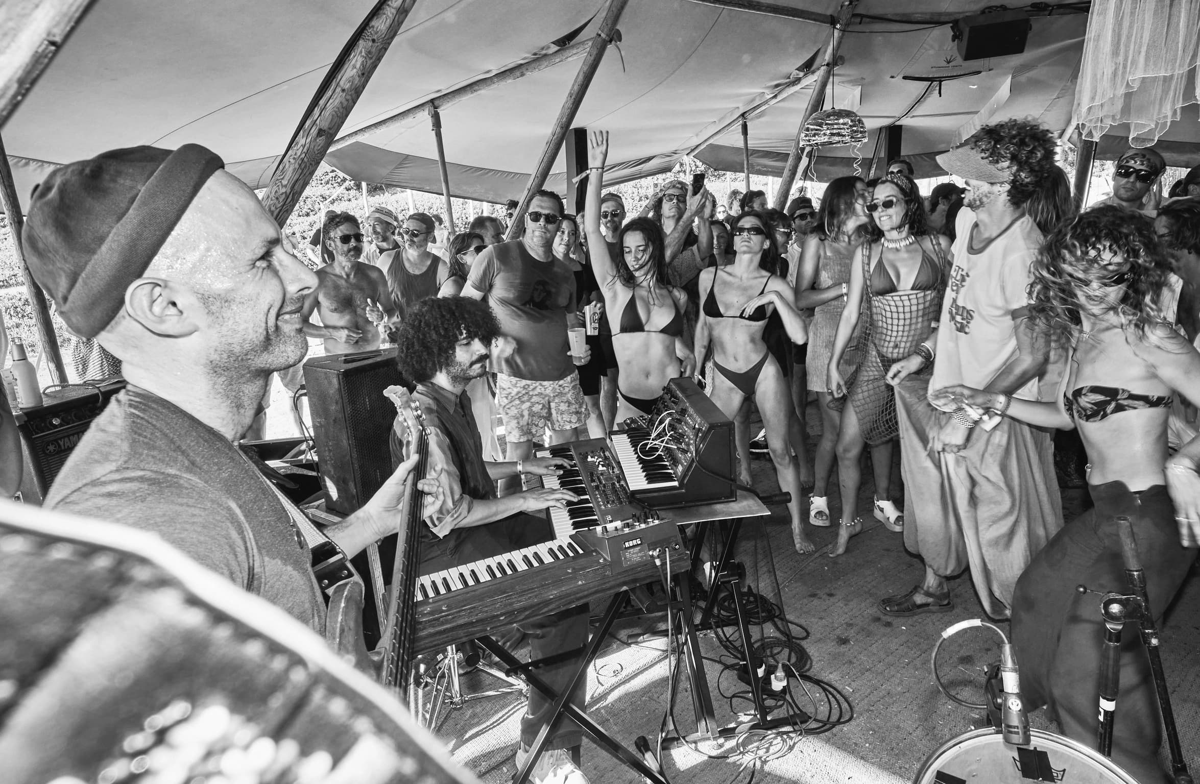 Musicians performing among the crowd in the ISLA Festival tipi